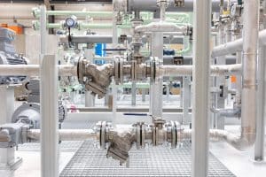 Stainless steel Y strainer with ball valve in a skid-mounted industrial unit with oil pumps for oils and viscous media